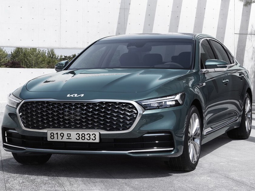 KIA K9 (II поколение рестайлинг, 2021 - 2022 г.в.): вид спереди сбоку у здания