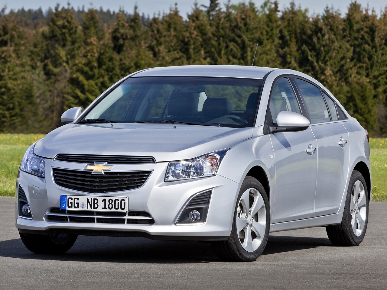 Chevrolet Cruze седан 1.4t AT LTZ: Три четверти спереди на асфальте среди деревьев