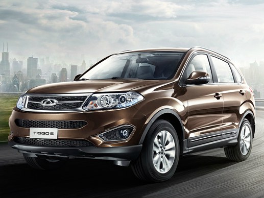 Chery Tiggo 5 2.0 MT Comfort: вид спереди сбоку на дороге на фоне небоскрёбов