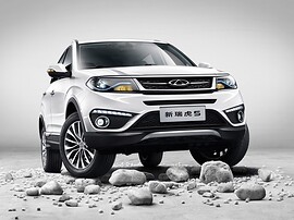 Chery Tiggo 5 (I поколение рестайлинг, 2015 - 2020 г.в.): вид спереди сбоку на камнях на сером фоне
