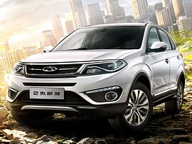 Chery Tiggo 5 (I поколение рестайлинг, 2015 - 2020 г.в.): вид спереди сбоку на городской улице на закате