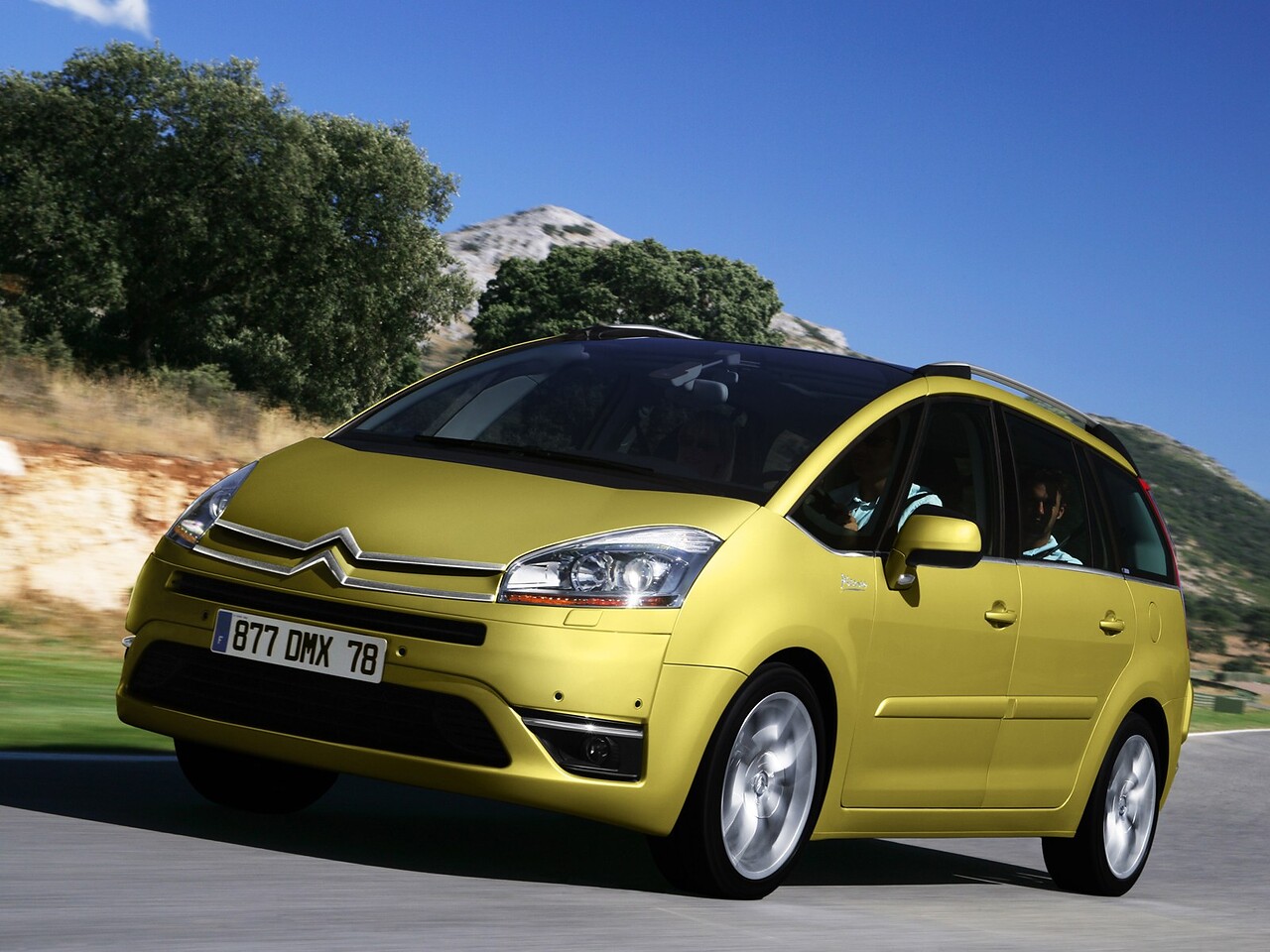 Citroen C4 Grand Picasso (I поколение, 2006 - 2014 г.в.): Три четверти спереди на дороге на фоне холмов