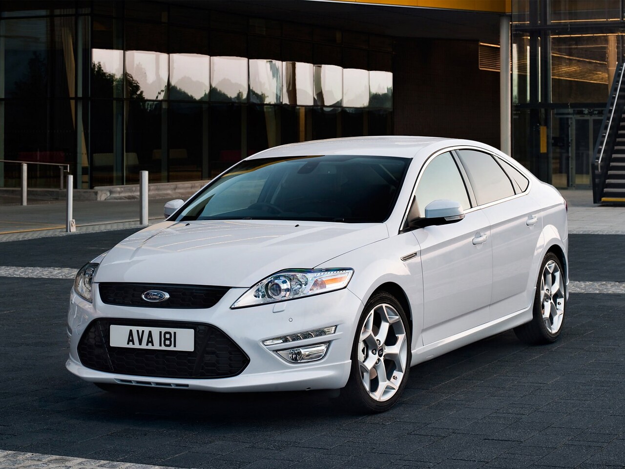 Ford Mondeo лифтбек 2.0 MT Trend: Три четверти спереди у стеклянного здания и моста