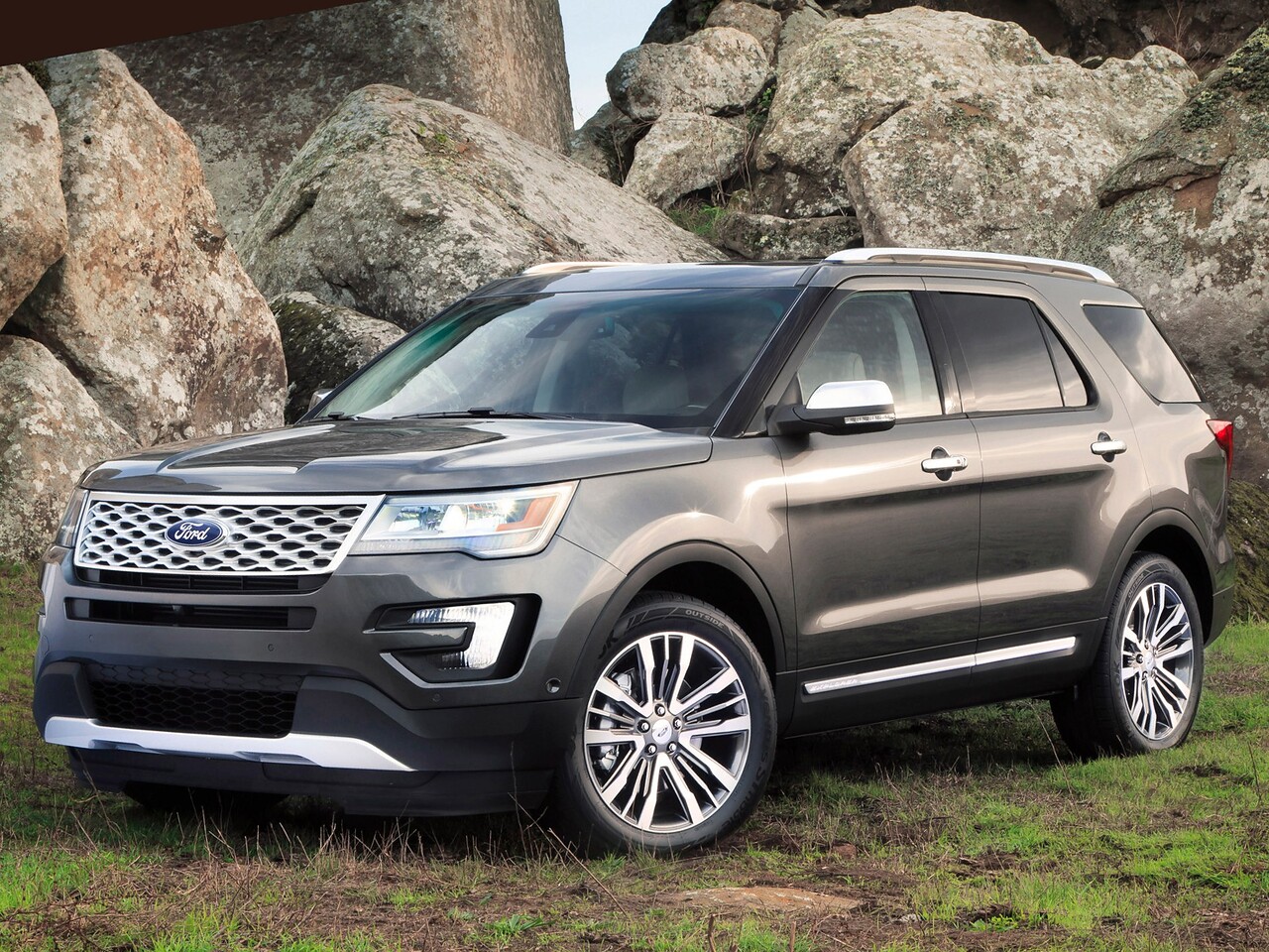 Ford Explorer (V поколение рестайлинг, 2015 - 2017 г.в.): Три четверти спереди среди валунов, тёмно-серый кузов