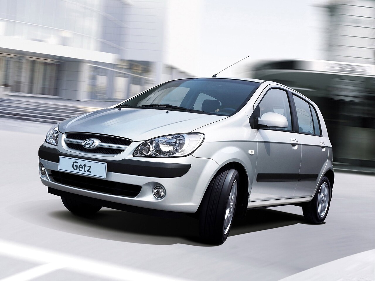 Hyundai Getz хэтчбек 5-дв. (I поколение, 2002 - 2010 г.в.): Серебристый хэтчбек в движении по городу, вид спереди сбоку