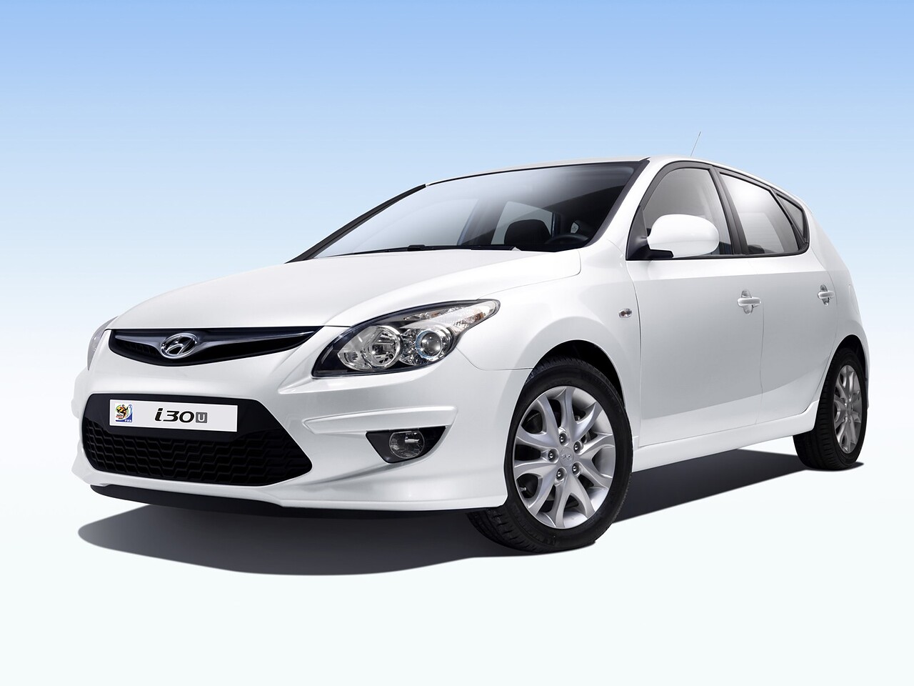 Hyundai i30 1.6 AT Optima: Белый хэтчбек на светлом фоне, вид спереди сбоку