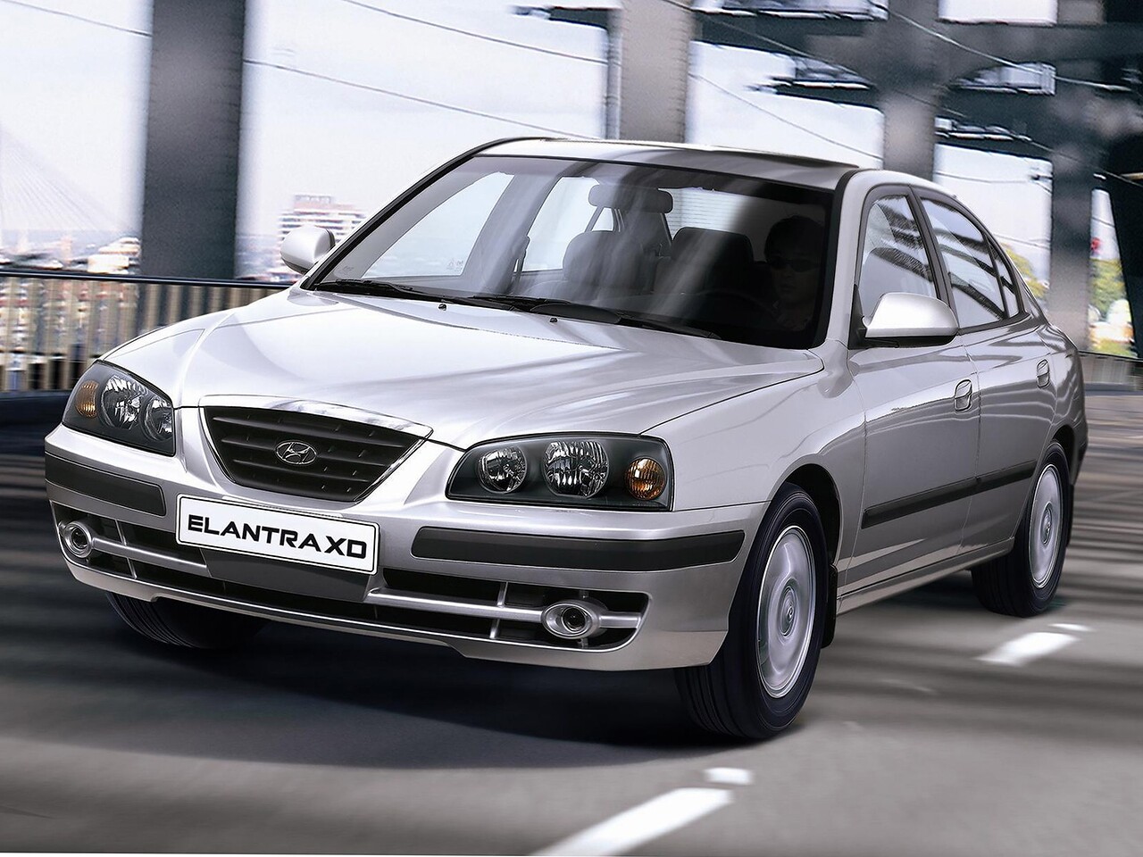 Hyundai Elantra XD 1.6 AT GL AT3: Серебристый седан в движении по дороге, вид спереди сбоку