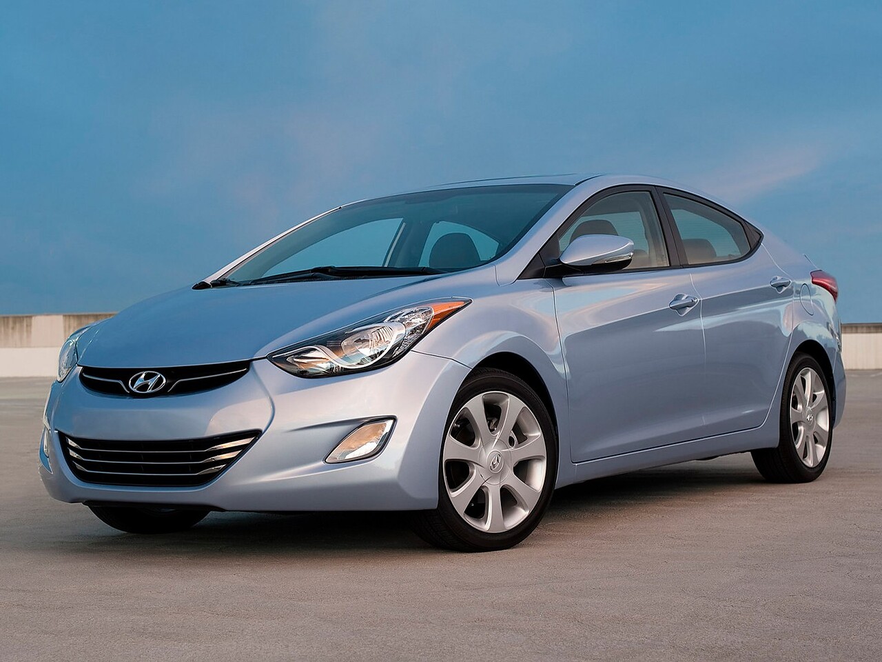 Hyundai Elantra (V поколение, 2011 - 2014 г.в.): Голубой седан на светлой площадке, вид спереди сбоку