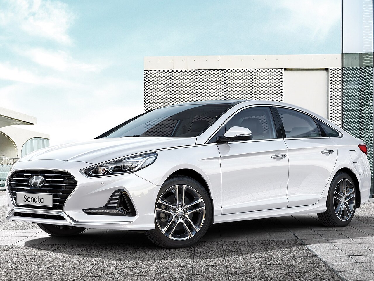 Hyundai Sonata 2.0 AT Primary: Белый седан у современного здания, вид спереди сбоку