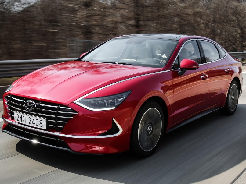 Hyundai Sonata (VIII поколение, 2019 - 2022 г.в.): Красный седан в движении по дороге, вид спереди сбоку