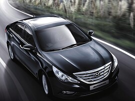 Hyundai Sonata (VI поколение, 2010 - 2015 г.в.): Красный седан в тёмной студии, вид спереди сбоку