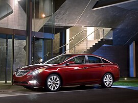 Hyundai Sonata (VI поколение, 2010 - 2015 г.в.): Красный седан у здания, боковой профиль