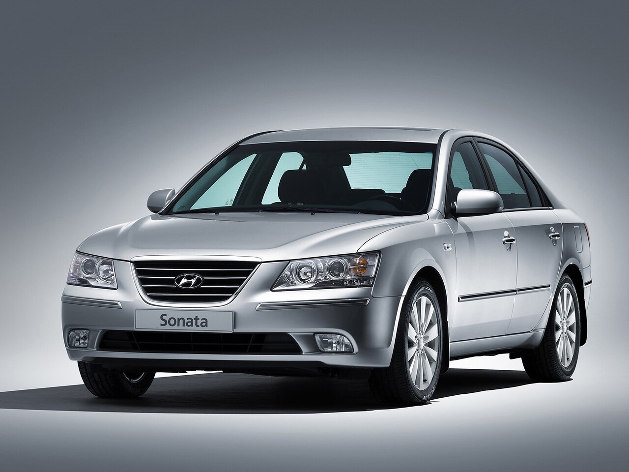 Hyundai NF Sonata (V поколение, 2004 - 2010 г.в.): Серебристый седан на сером фоне, вид спереди сбоку