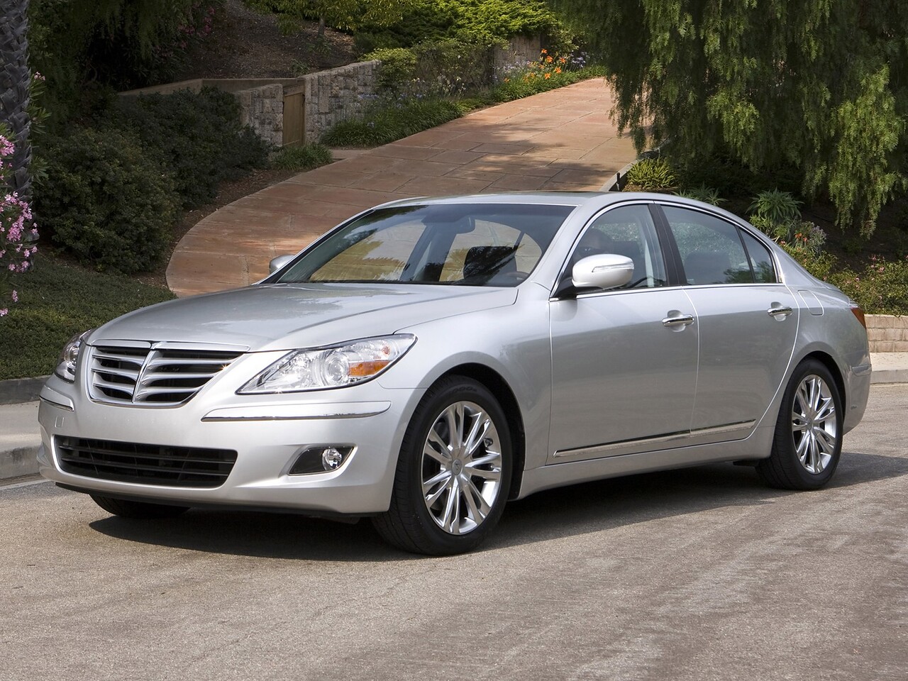 Hyundai Genesis седан (I поколение, 2008 - 2011 г.в.): Серебристый седан на дороге у деревьев, вид спереди сбоку