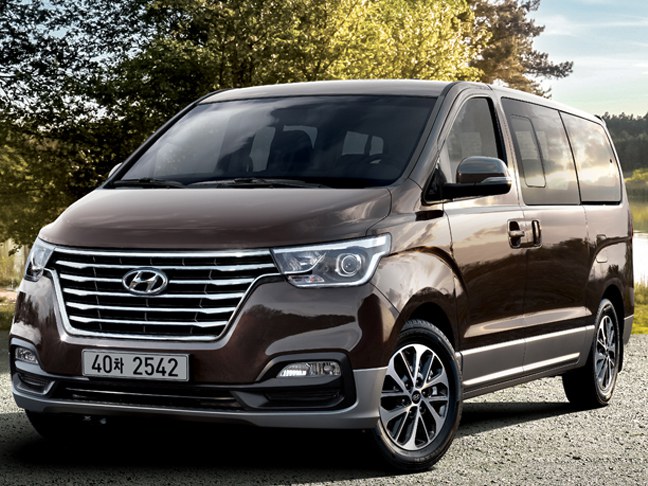 Hyundai H-1 (II поколение рестайлинг, 2017 - 2021 г.в.): Коричневый минивэн в парке, вид спереди сбоку