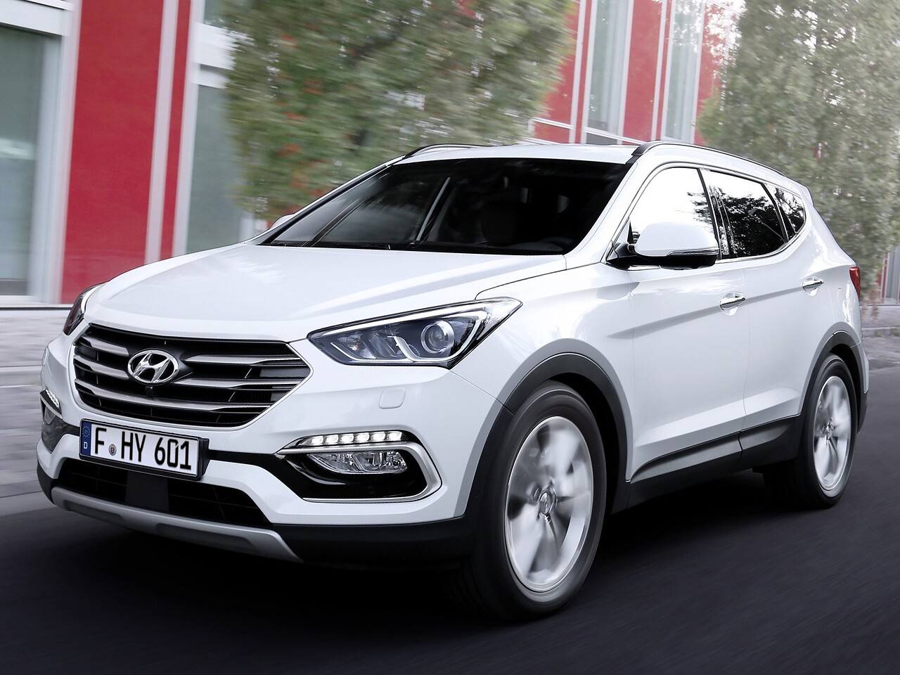 Hyundai Santa Fe 2.2 CRDi AT Dynamic: Белый кроссовер в движении, вид спереди сбоку
