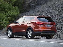 Hyundai Santa Fe (III поколение, 2012 - 2015 г.в.): Медный кроссовер у скалы, вид сзади сбоку