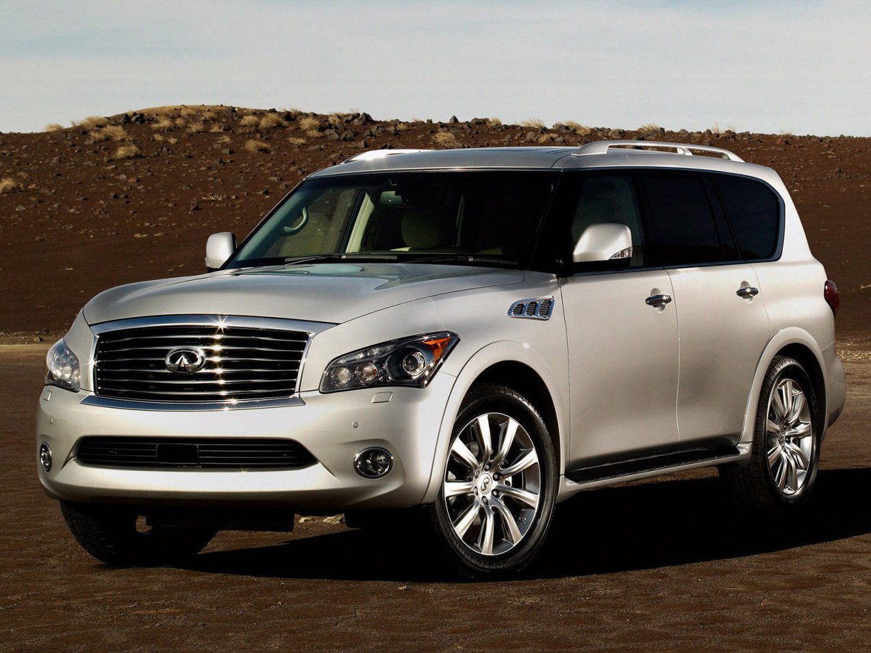 Infiniti QX 5.6 AT: Три четверти спереди в пустынной долине у гор