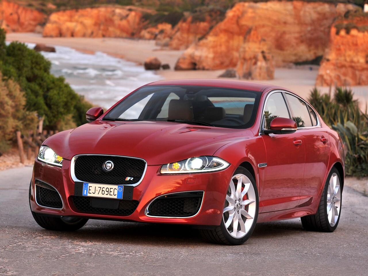 Jaguar XF R (I поколение рестайлинг, 2011 - 2015 г.в.): Три четверти спереди у морского побережья со скалами