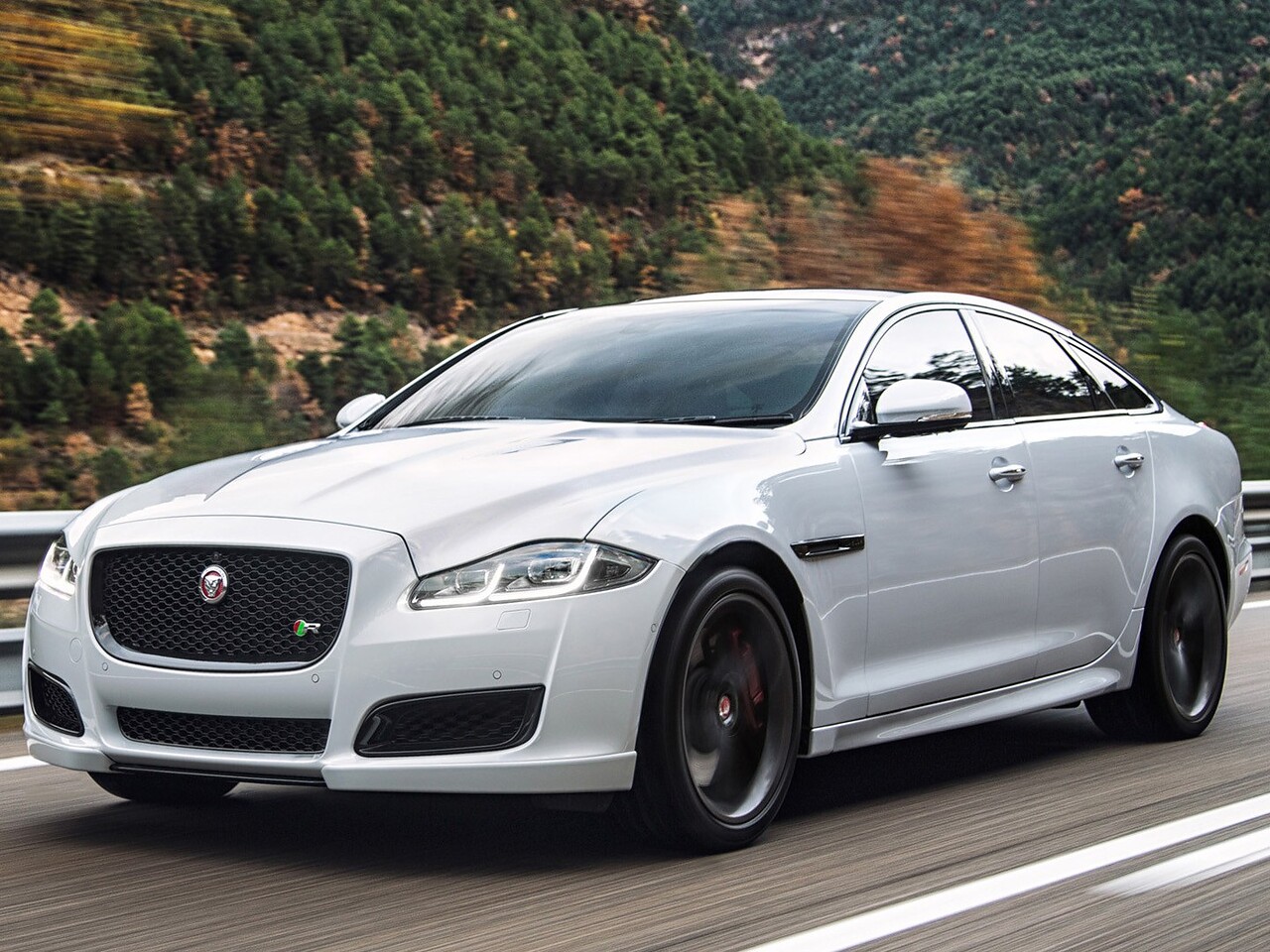 Jaguar XJ седан (V поколение рестайлинг, 2015 - 2021 г.в.): Три четверти спереди в движении на горной дороге