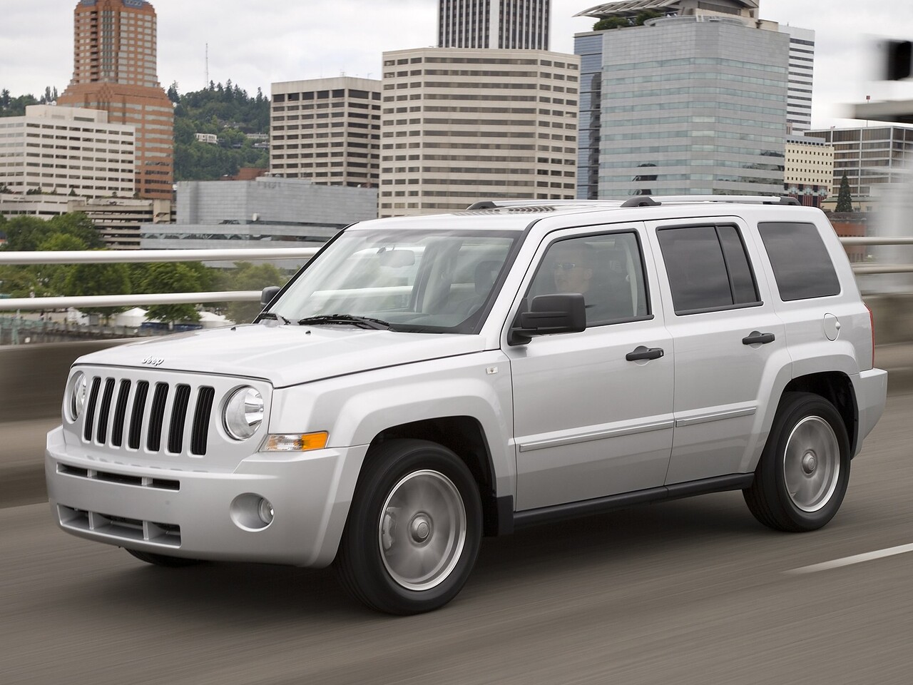 Jeep Liberty (II поколение, 2007 - 2011 г.в.): Три четверти спереди в движении на городской улице