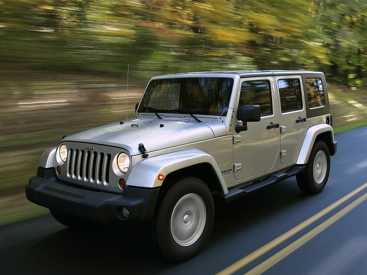Jeep Wrangler Unlimited 5-дв. (II поколение, 2006 - 2018 г.в.): Три четверти спереди в движении на дороге