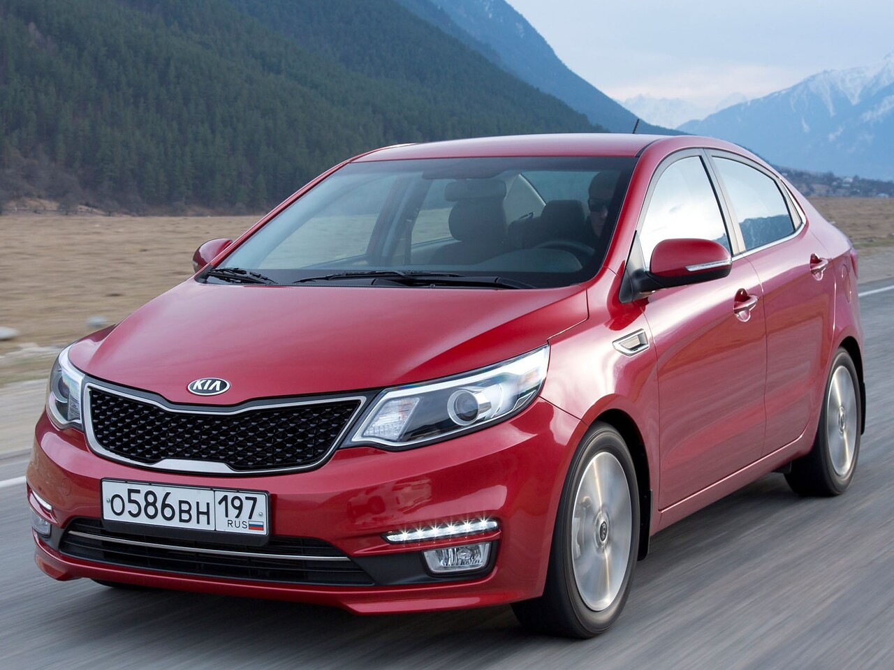 KIA Rio седан 1.4 MT Comfort: Три четверти спереди в движении у гор