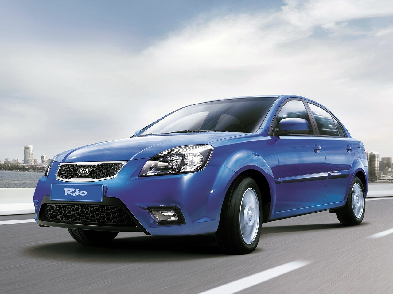 KIA Rio седан 1.4 MT Classic: Три четверти спереди в движении по шоссе