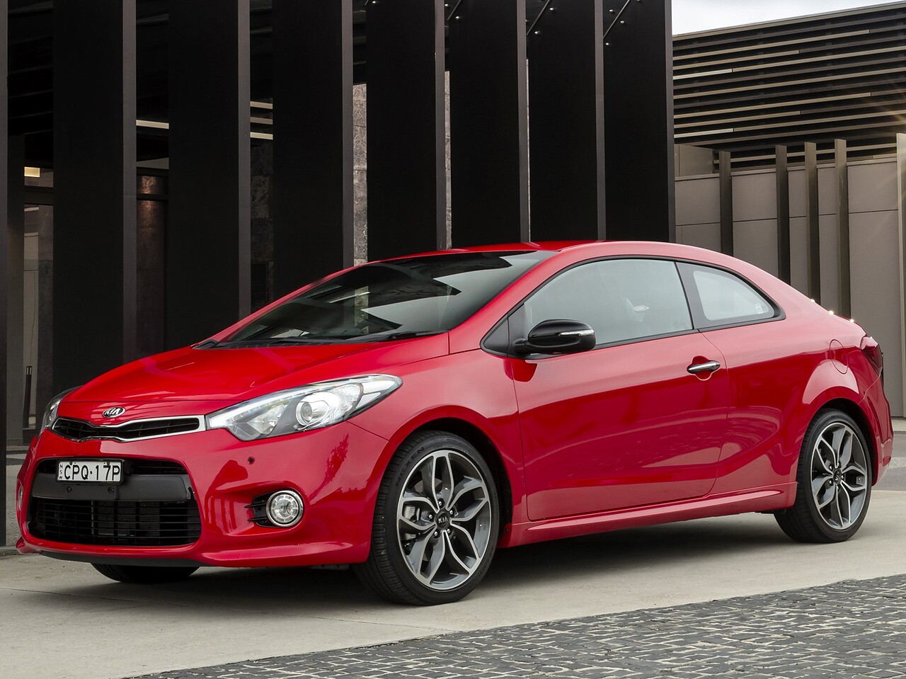 KIA Cerato KOUP (III поколение, 2013 - 2014 г.в.): Три четверти спереди у современного здания