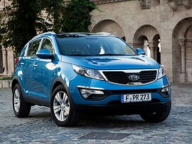 KIA Sportage (III поколение, 2010 - 2014 г.в.): Три четверти спереди у каменного здания