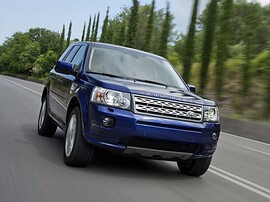 Land Rover Freelander 2 (II поколение рестайлинг, 2010 - 2012 г.в.): Вид спереди сбоку среди деревьев
