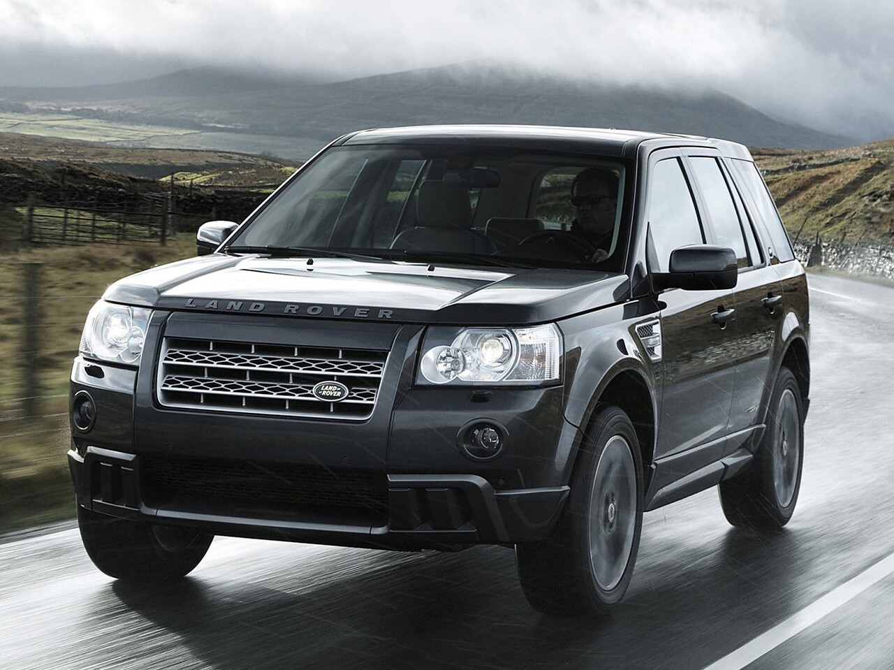 Land Rover Freelander 2 (II поколение рестайлинг, 2010 - 2012 г.в.): Вид спереди сбоку на мокрой дороге