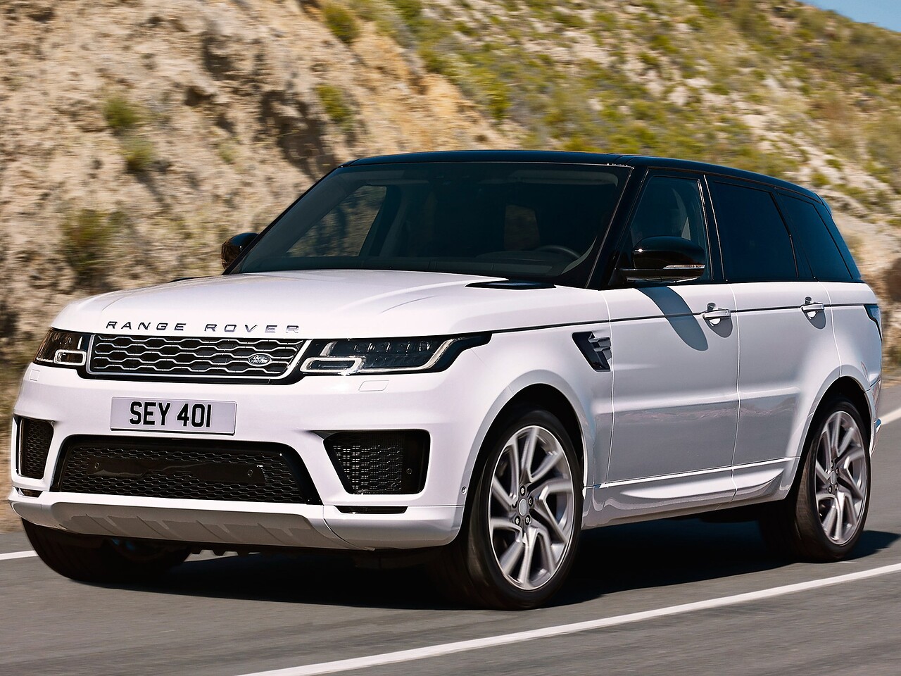 Land Rover Range Rover Sport: Вид спереди сбоку на дороге в холмах, белый кузов