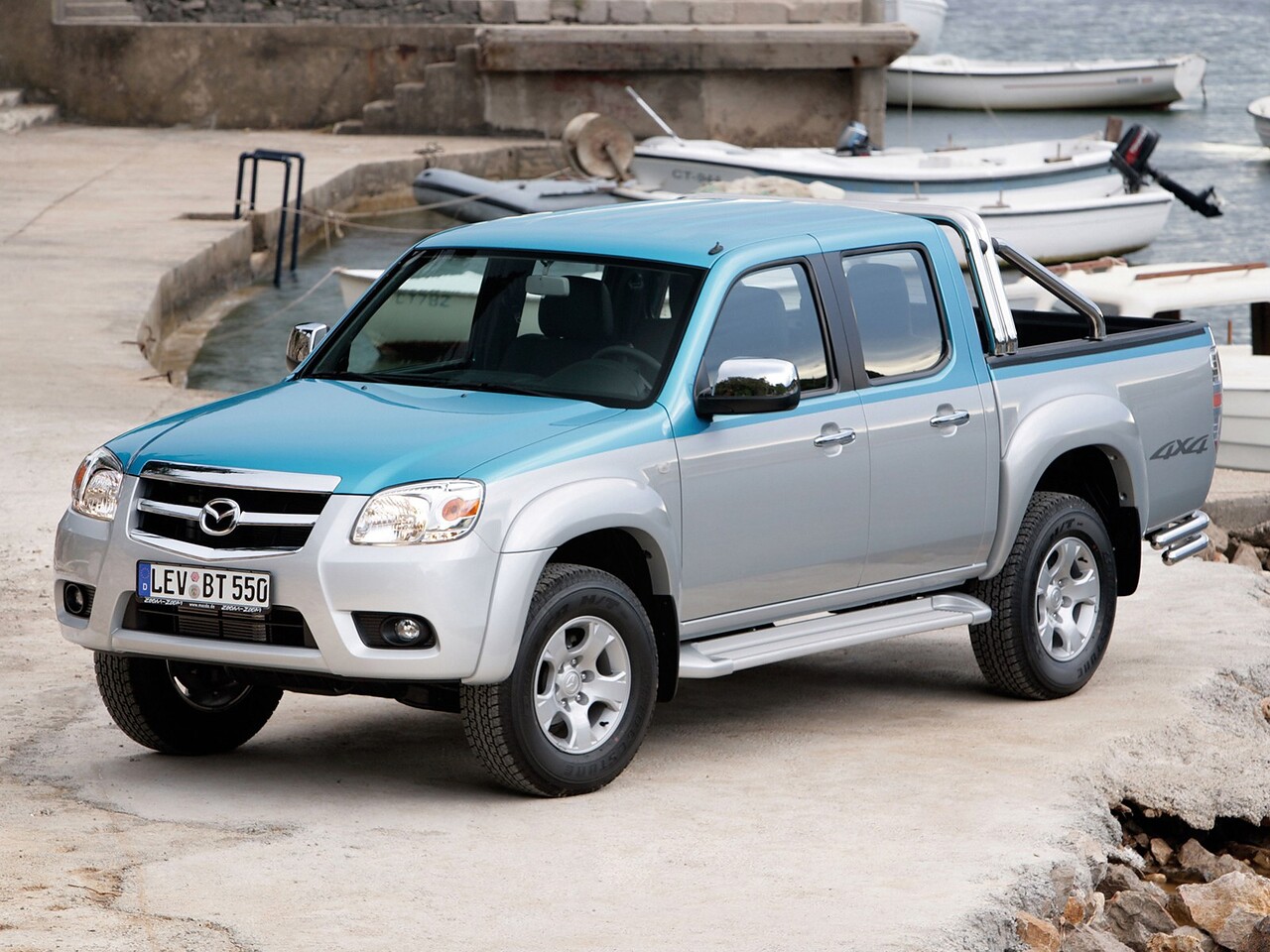 Mazda BT-50 2.5 MT Direct: Серебристый пикап с голубыми акцентами в гавани, вид спереди сбоку