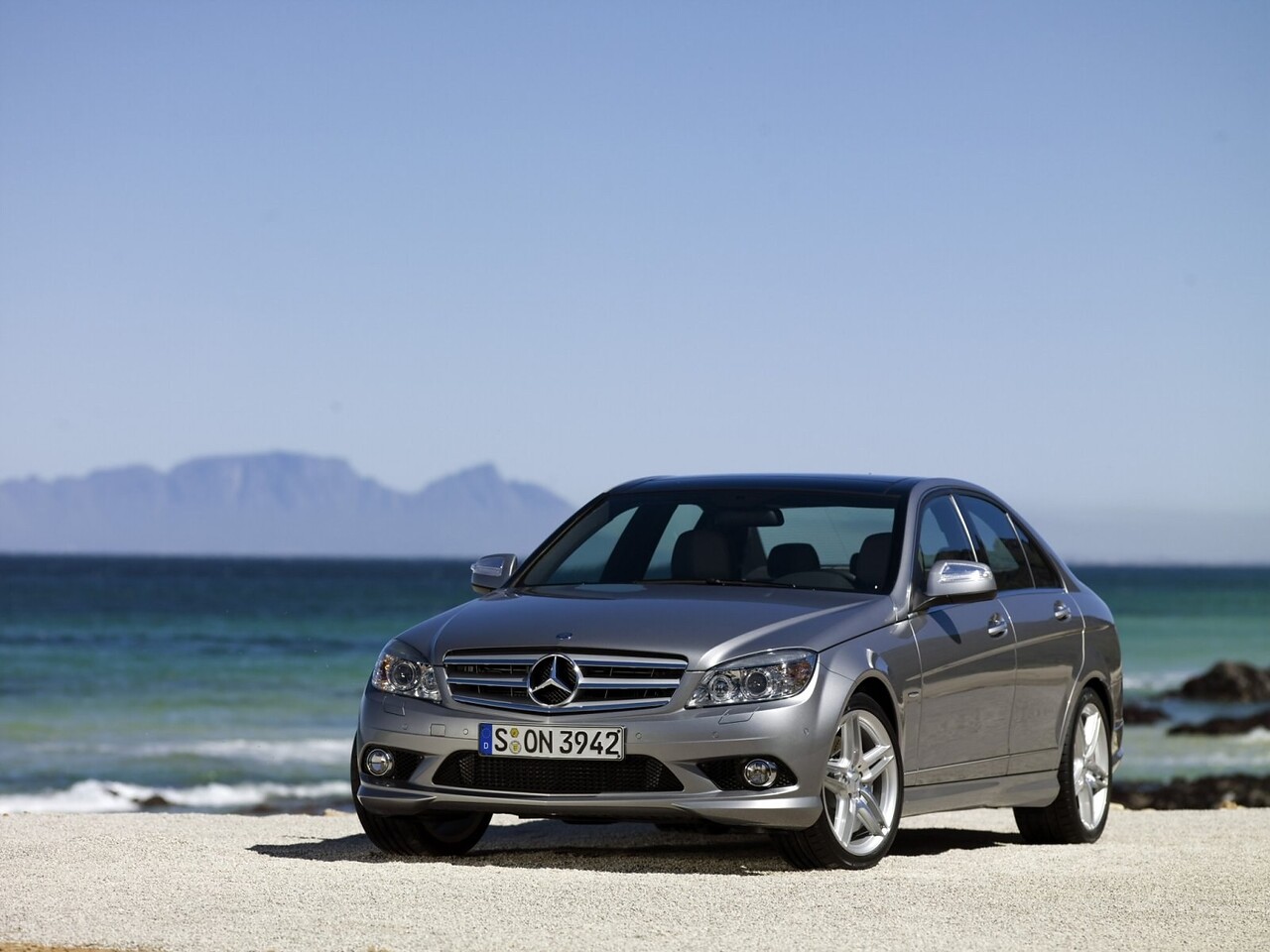 Mercedes-Benz C-Класс седан 1.8 AT C 200 CGI: Серебристый седан на пляже, вид спереди сбоку