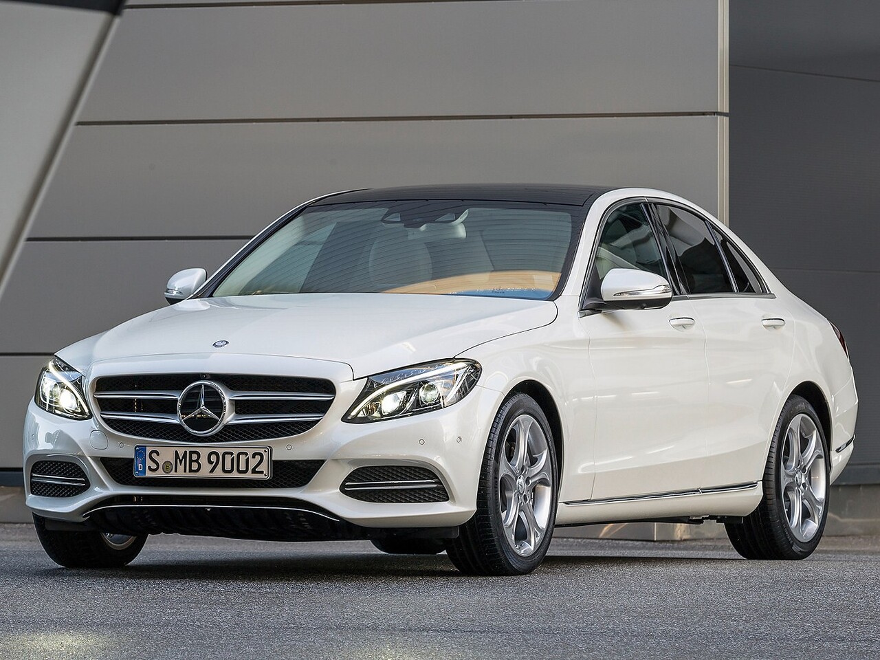 Mercedes-Benz C-Класс седан (W205, 2013 - 2018 г.в.): Белый седан в городе, вид спереди сбоку