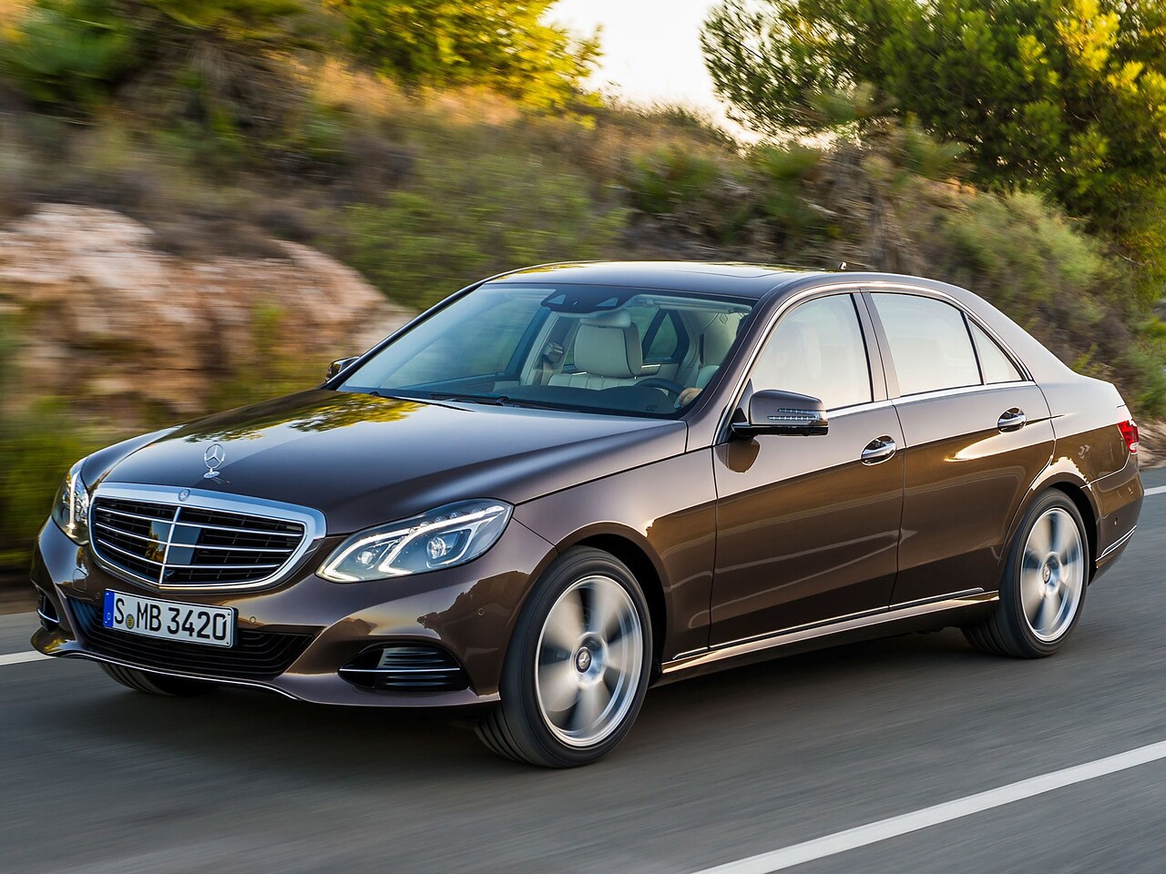 Mercedes-Benz E-Класс седан (W212 рестайлинг, 2013 - 2016 г.в.): Коричневый седан в движении, вид спереди сбоку