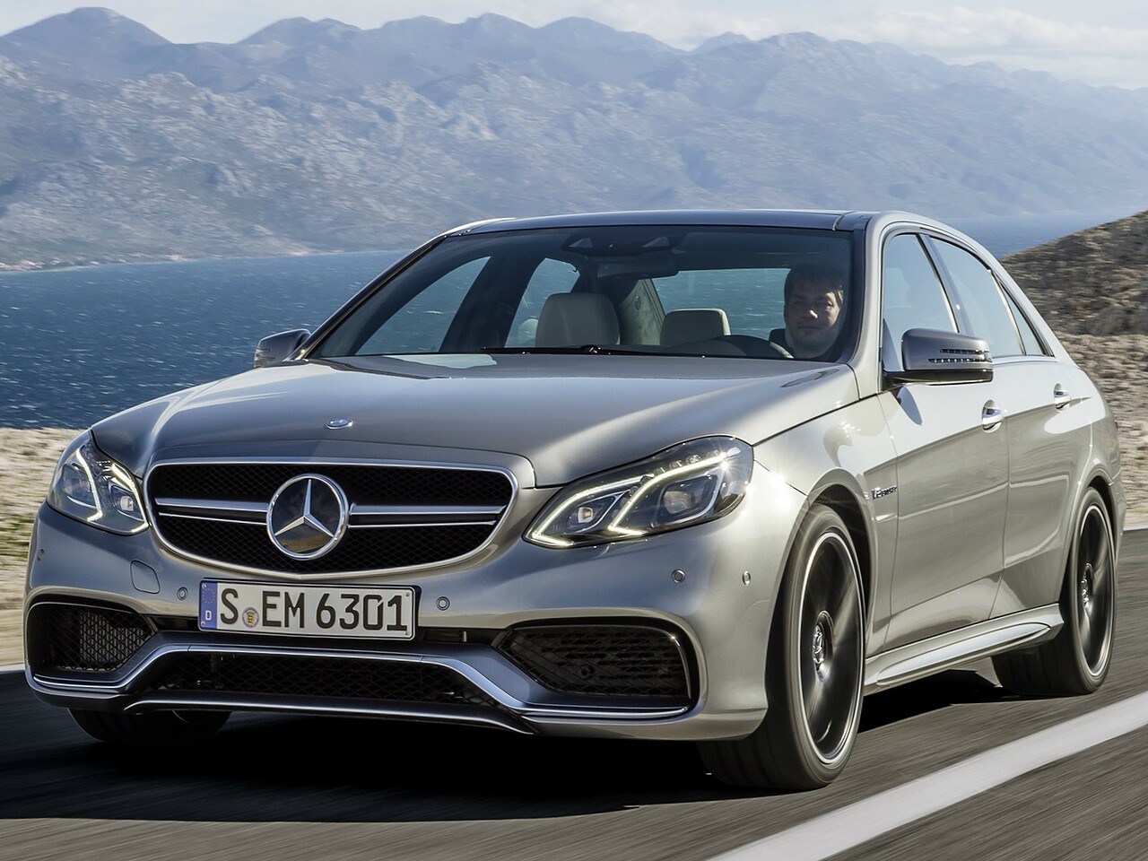 Mercedes-Benz E-Класс AMG седан 5.5 4MATIC  AT E63: Серебристый седан на побережье, вид спереди сбоку