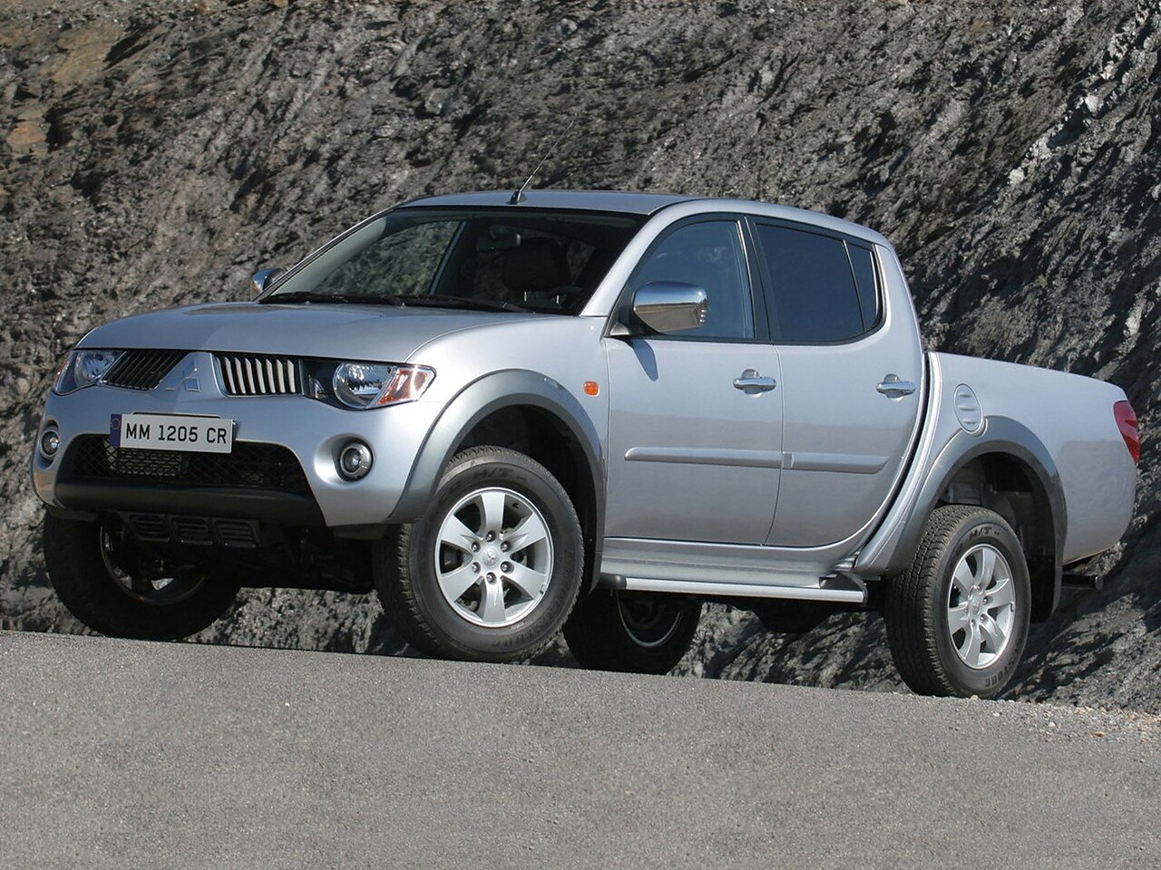 Mitsubishi L200 4-дв. (IV поколение, 2006 - 2015 г.в.): Три четверти спереди у скалы