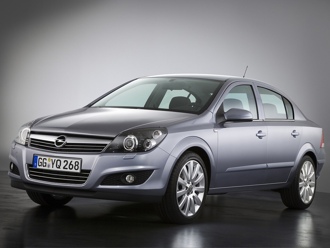 Opel Astra седан (H, 2007 - 2011 г.в.): Серебристый седан в студии, вид спереди