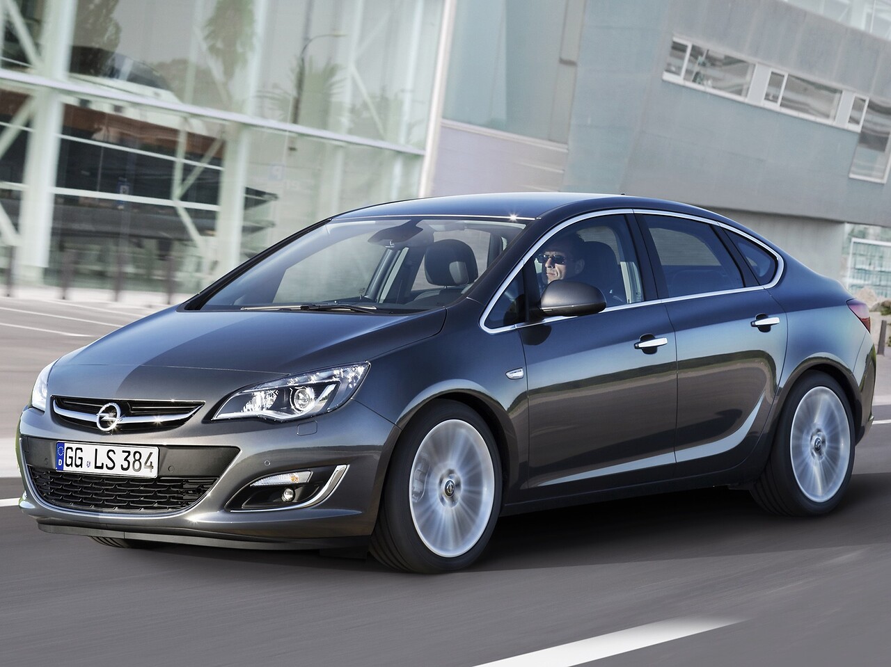 Opel Astra седан 1.6 MT Enjoy: Тёмно-серый седан в движении на дороге