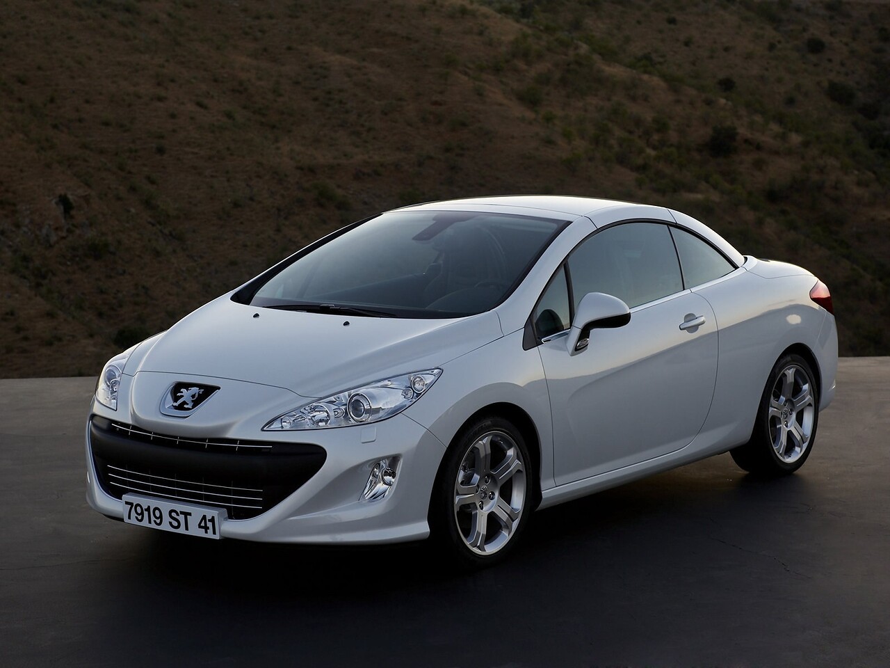 Peugeot 308 кабриолет 1.6 THP AT Feline: Три четверти спереди на дороге в сумерках