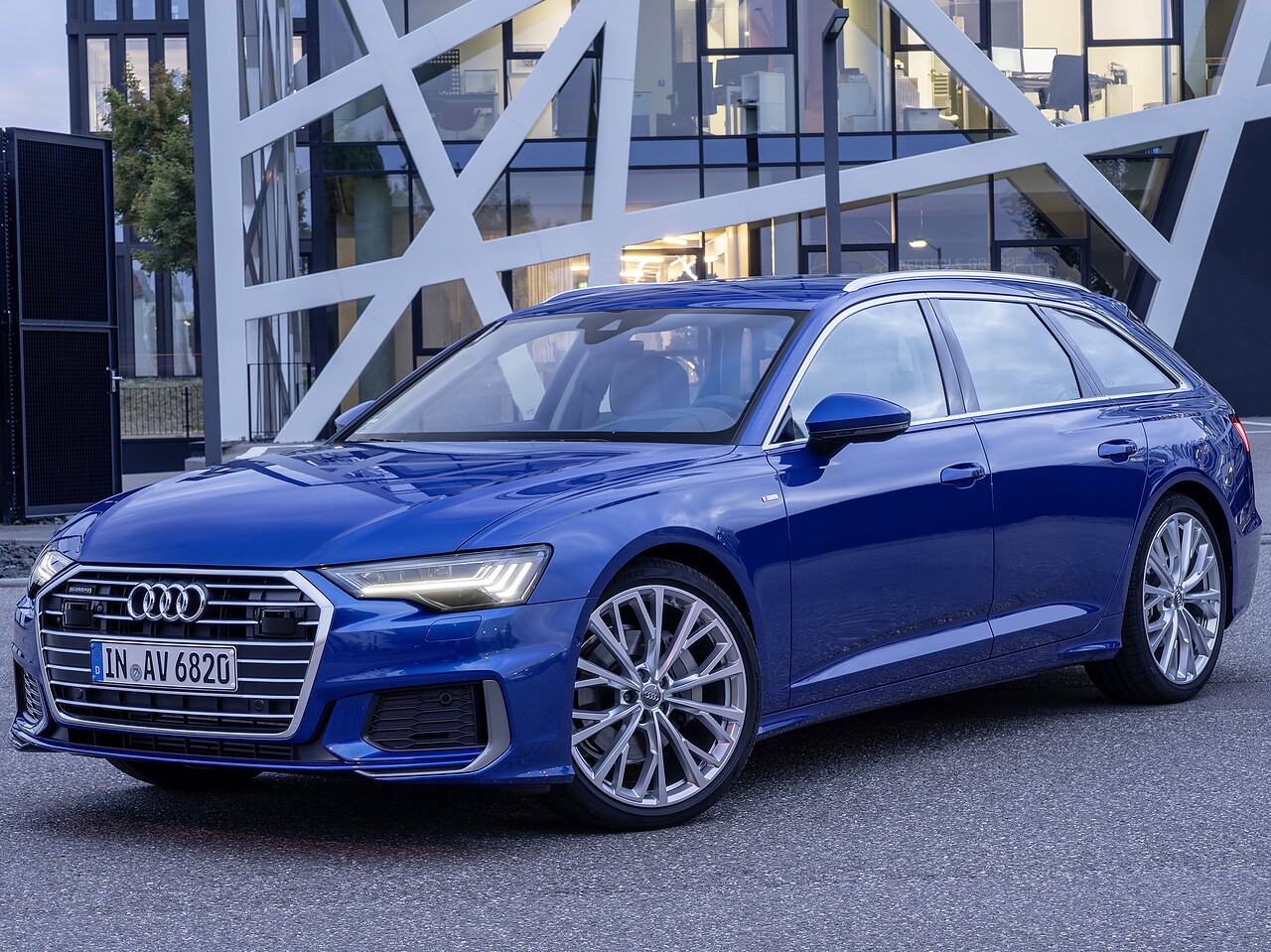 Audi A6 универсал 2.0 AT Базовая (40 TFSI): вид спереди сбоку у современного здания