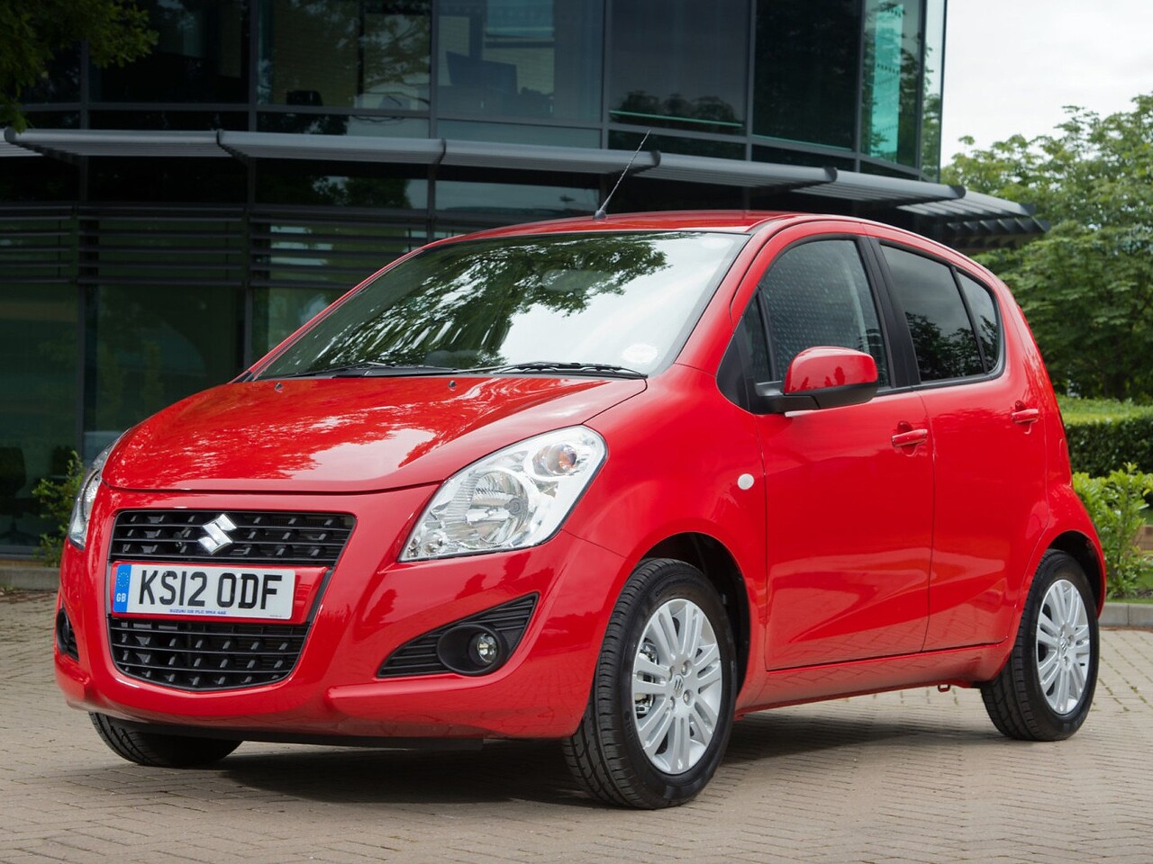 Suzuki Splash 1.2 AT GLS: Три четверти спереди у стеклянного здания
