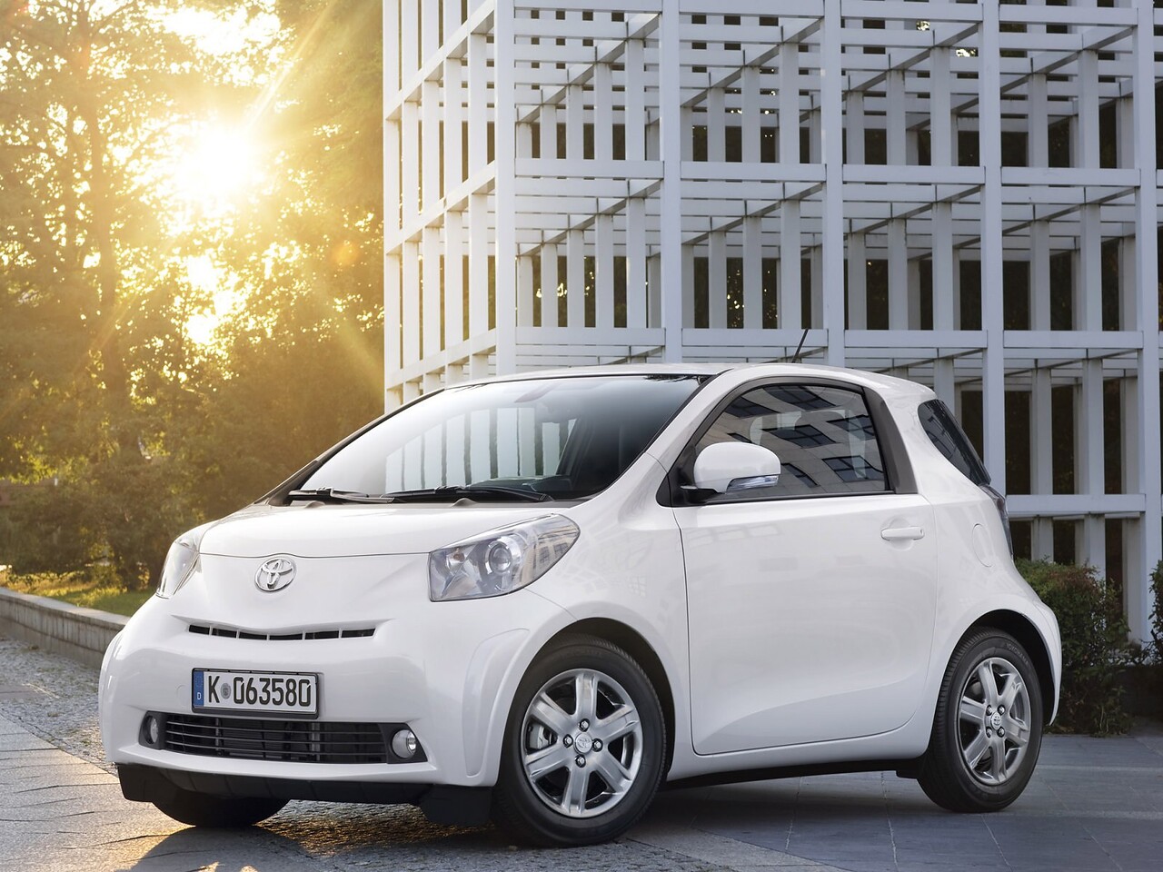 Toyota iQ (I поколение, 2009 - 2011 г.в.): Три четверти спереди у стеклянного здания