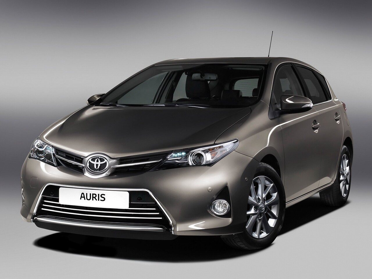 Toyota Auris 1.6 MT Комфорт Плюс: Три четверти спереди на сером фоне