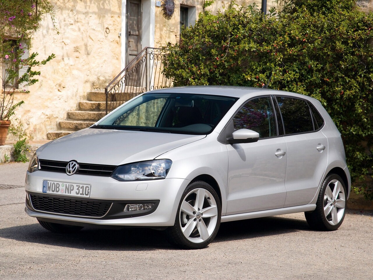 Volkswagen Polo хэтчбек 5-дв. (V поколение, 2010 - 2015 г.в.): вид спереди сбоку у каменной стены