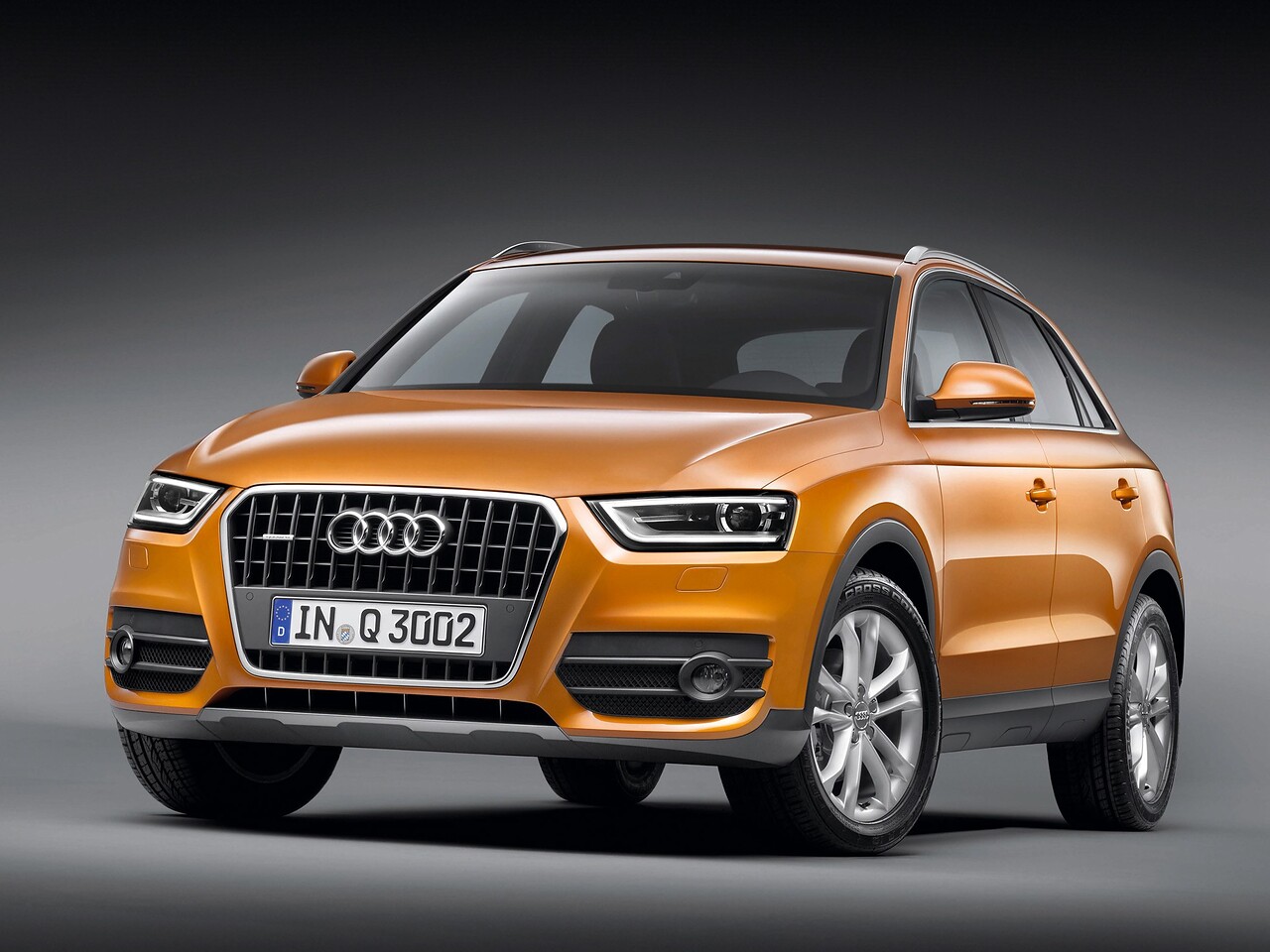 Audi Q3 (I поколение, 2011 - 2014 г.в.): Оранжевый кроссовер в студии, вид спереди сбоку