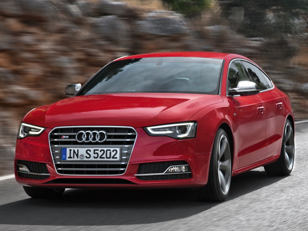 Audi S5 лифтбек (I поколение рестайлинг, 2011 - 2017 г.в.): Красный лифтбек на дороге, вид спереди сбоку
