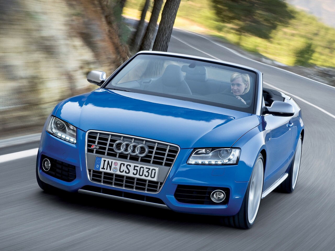 Audi S5 кабриолет 3.0 TFSI quattro AT: Синий кабриолет с открытым верхом на горной дороге, вид спереди сбоку